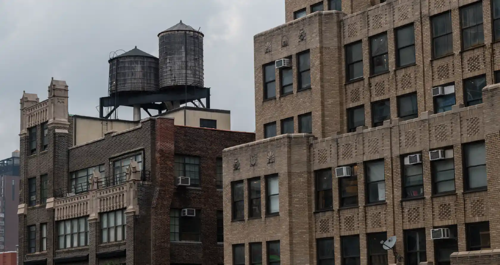 Urban apartment buildings with rooftop water tanks in city skyline