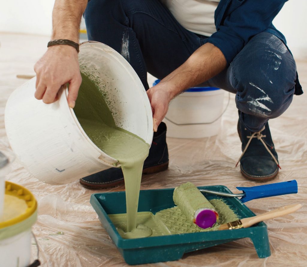 Contractor preparing paint and renovation materials inside an older home where lead-safe work practices may be required during pre-1978 property renovations.