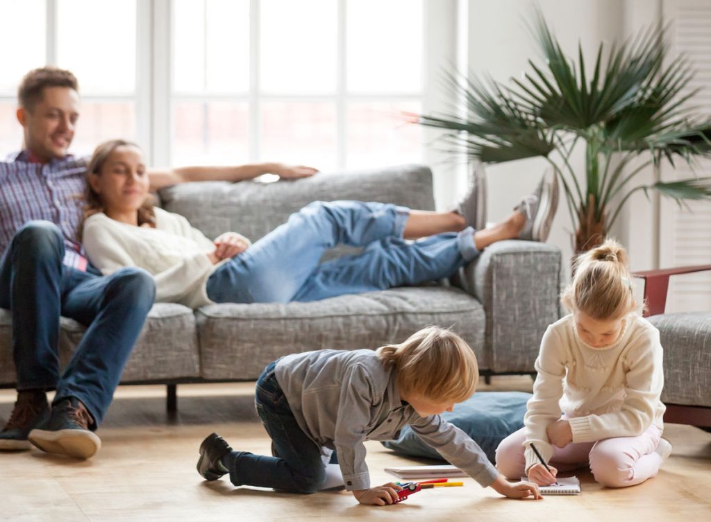 Family with young children inside an older home where lead paint testing and lead-safe maintenance may help reduce lead dust exposure risks in pre-1978 housing.