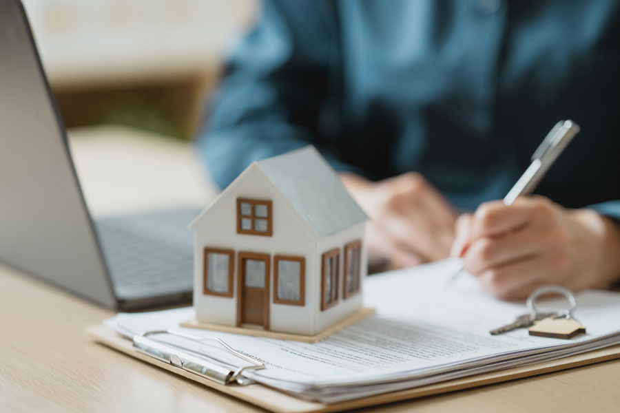 Home sale paperwork and house model representing selling a house with open violations in NYC and property disclosure requirements